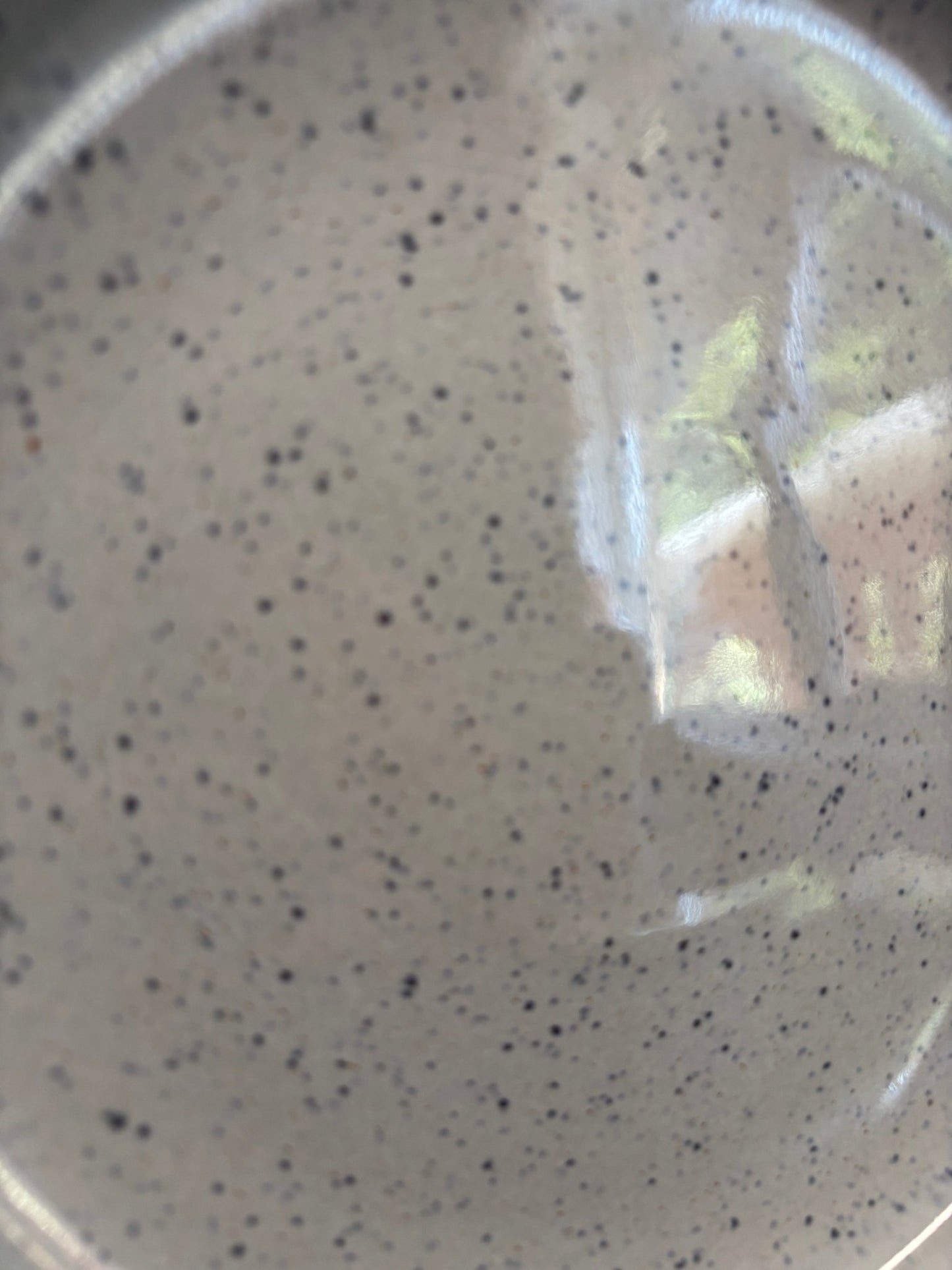 Speckled gray ceramic plate with a transparent plastic wrap on top