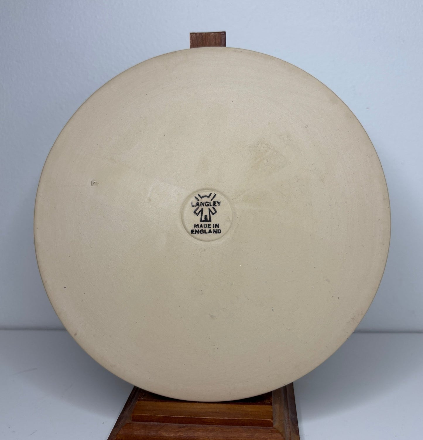 Round beige object with a visible brand logo on a white background