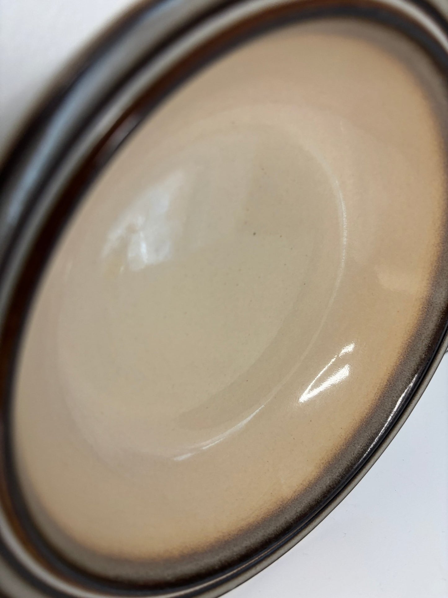 Close-up of a Denby Sonnet Soup bowl with a beige interior and black rim.