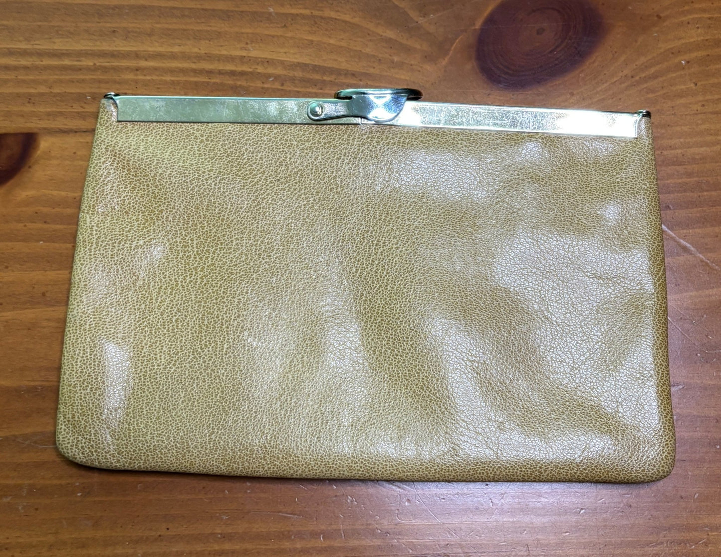 Gold clutch bag on a wooden surface