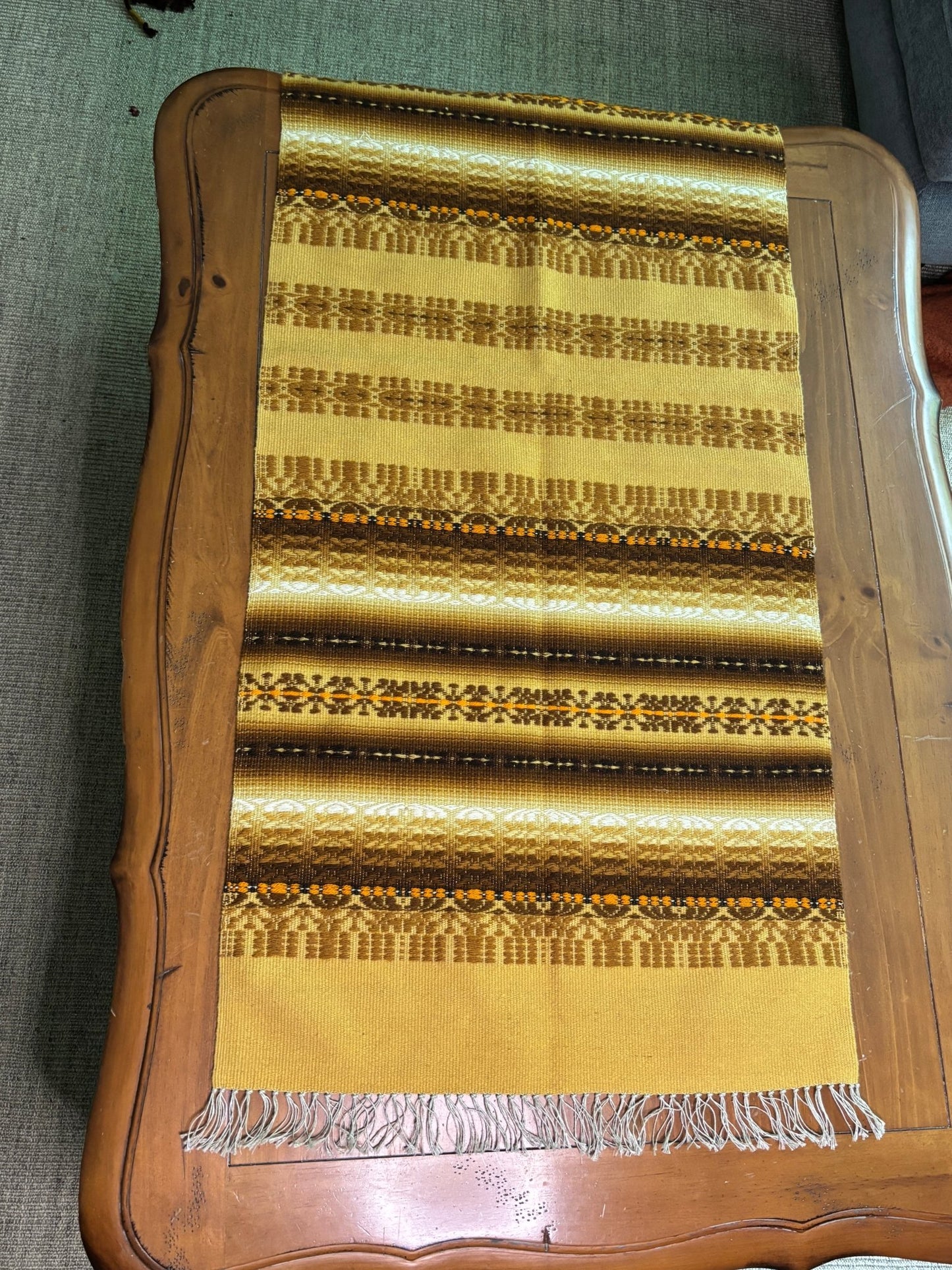 Decorative woven mat with a wooden frame on a textured surface