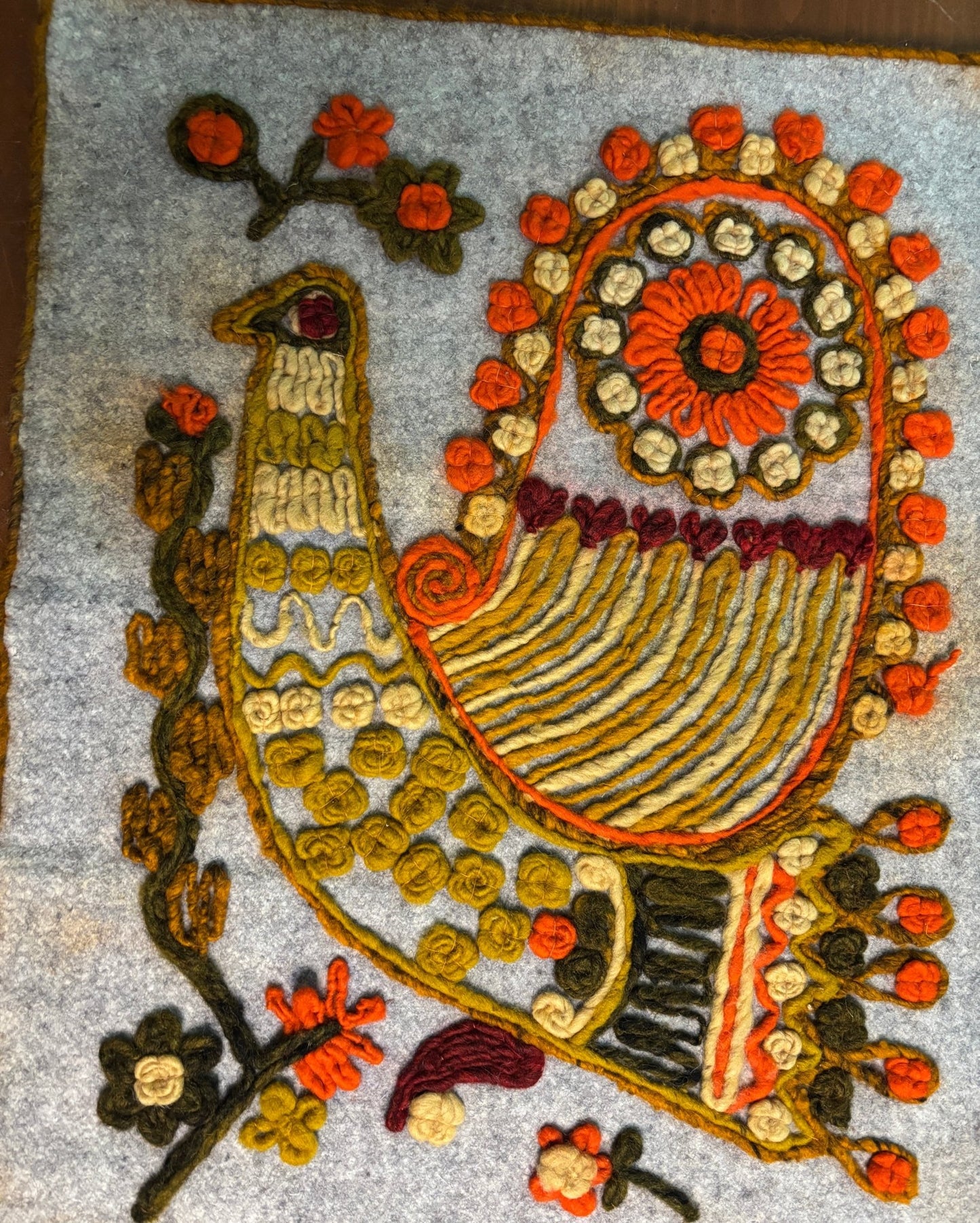 Decorative peacock design with flowers on a textured surface