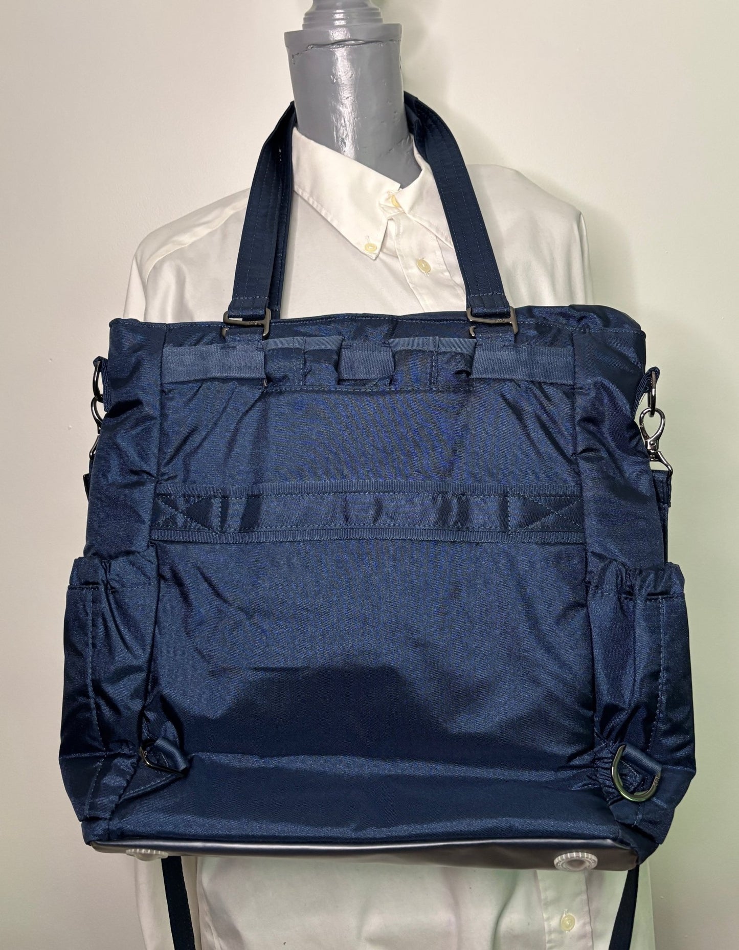 Navy blue backpack on a mannequin with a white shirt underneath