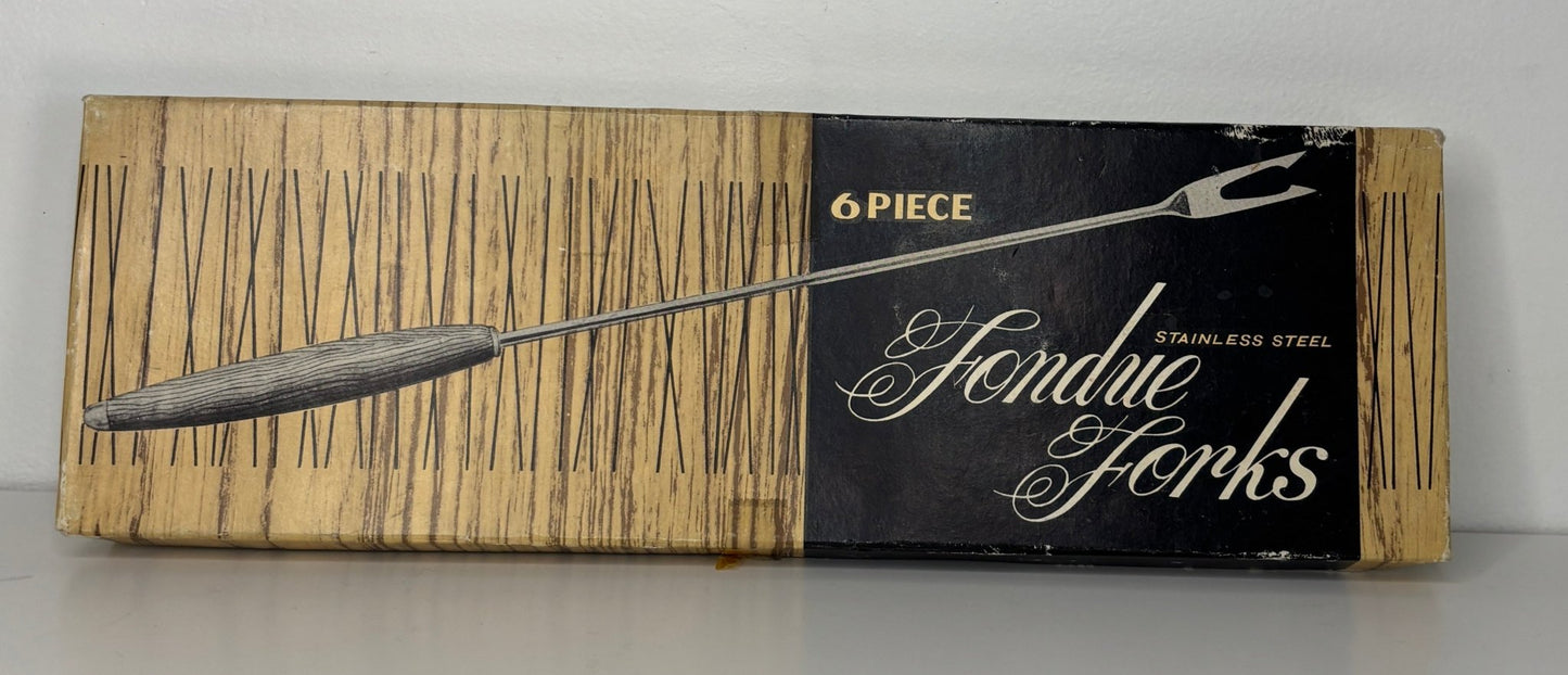 Box of Fendue forks with a silver fork illustration on a wooden background