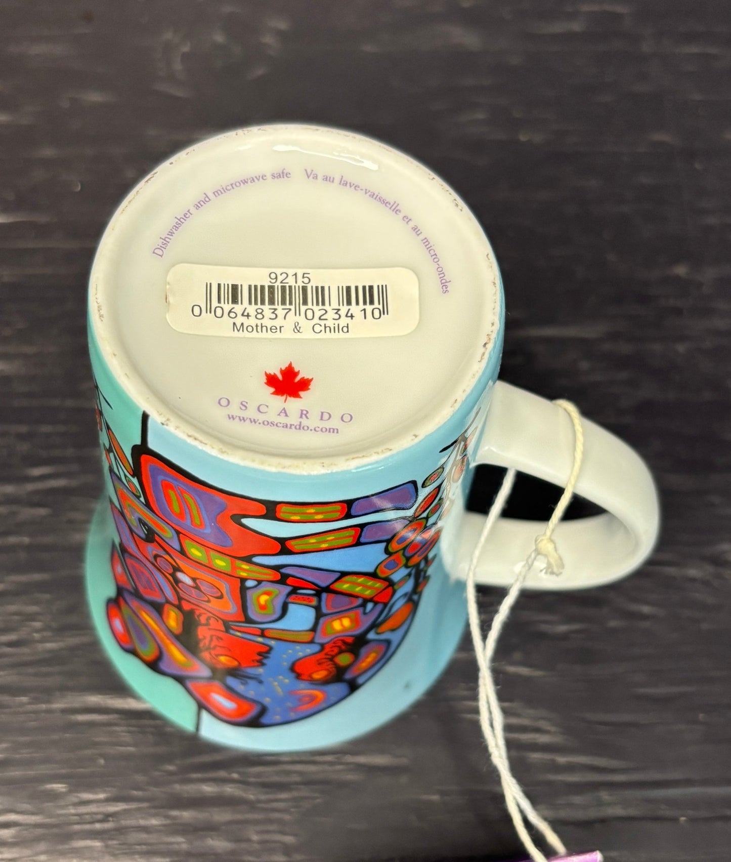 Colorful mug with a brand label on a dark surface