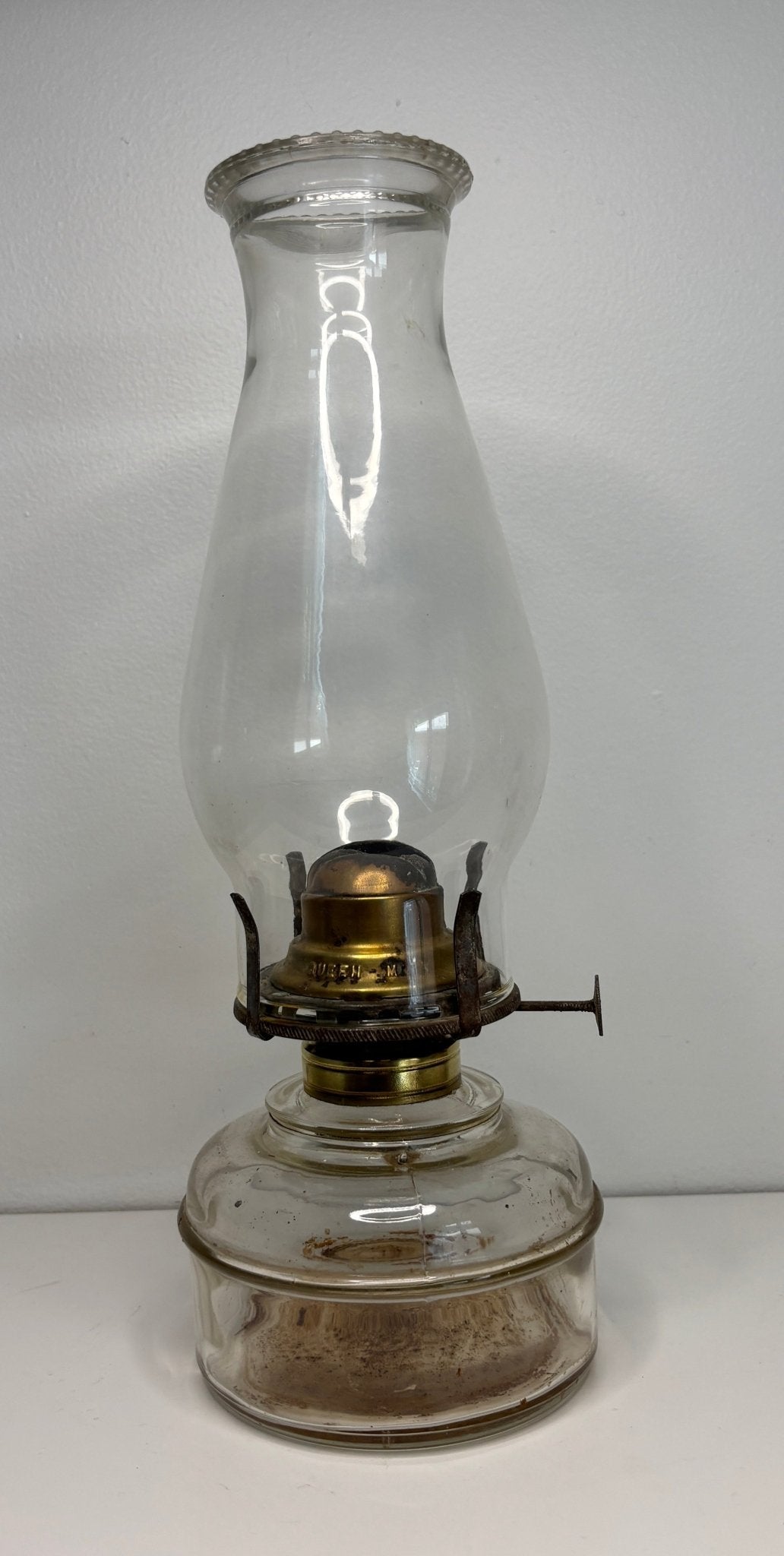 Clear glass oil lamp on a white background