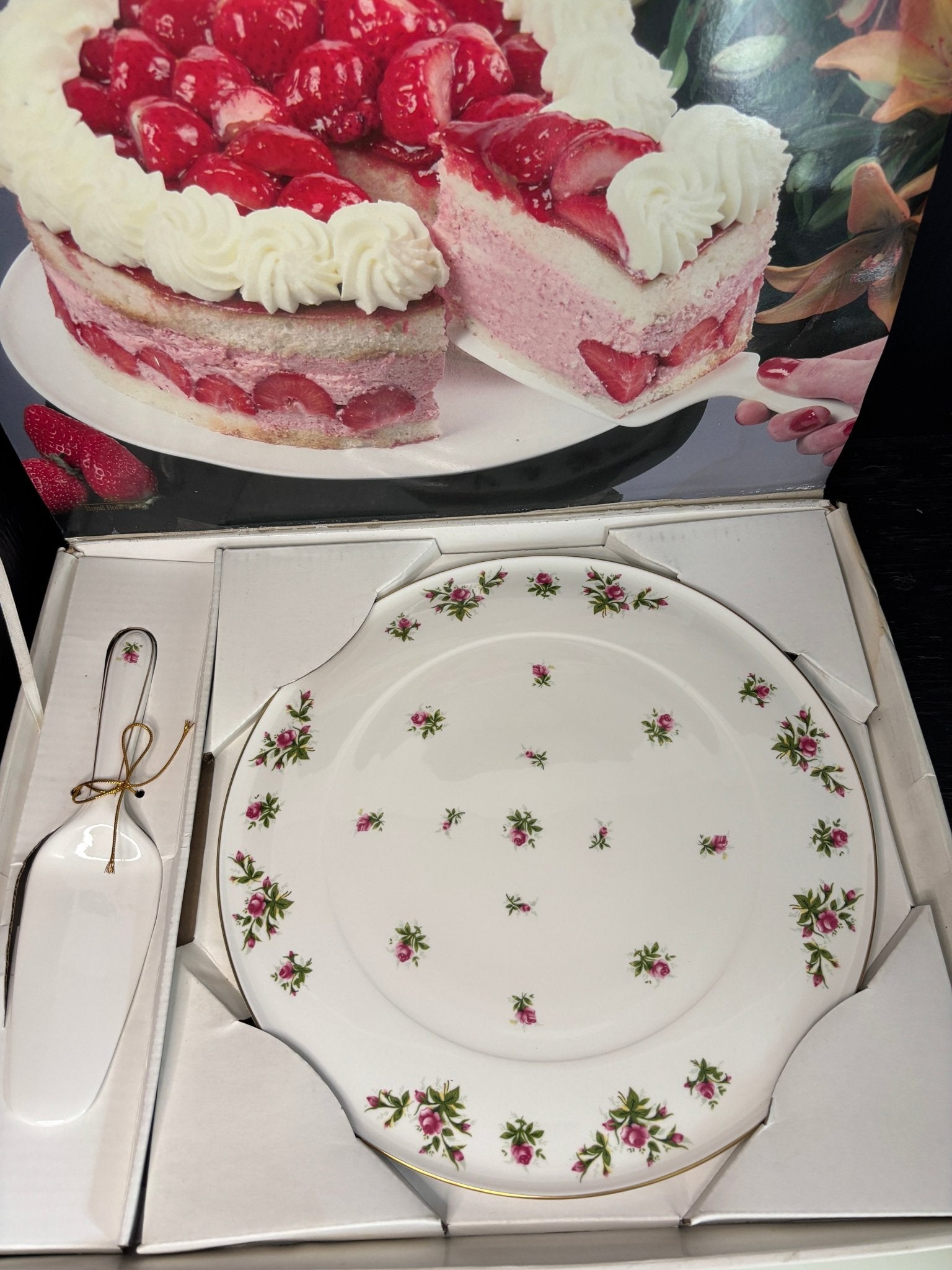 Decorative plate with floral pattern in a box, next to a cake image