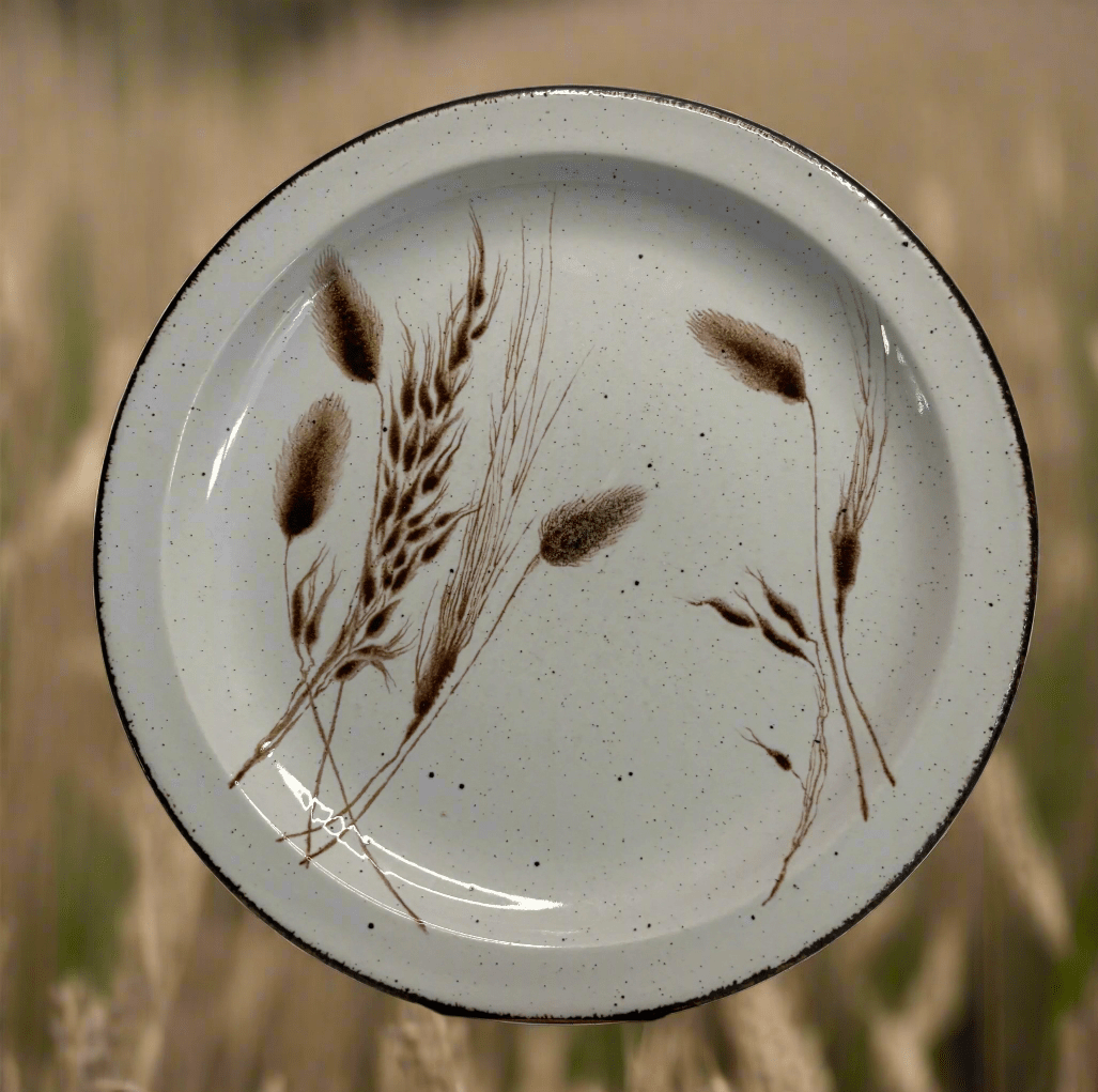 Ceramic plate with brown leaf design on a white background