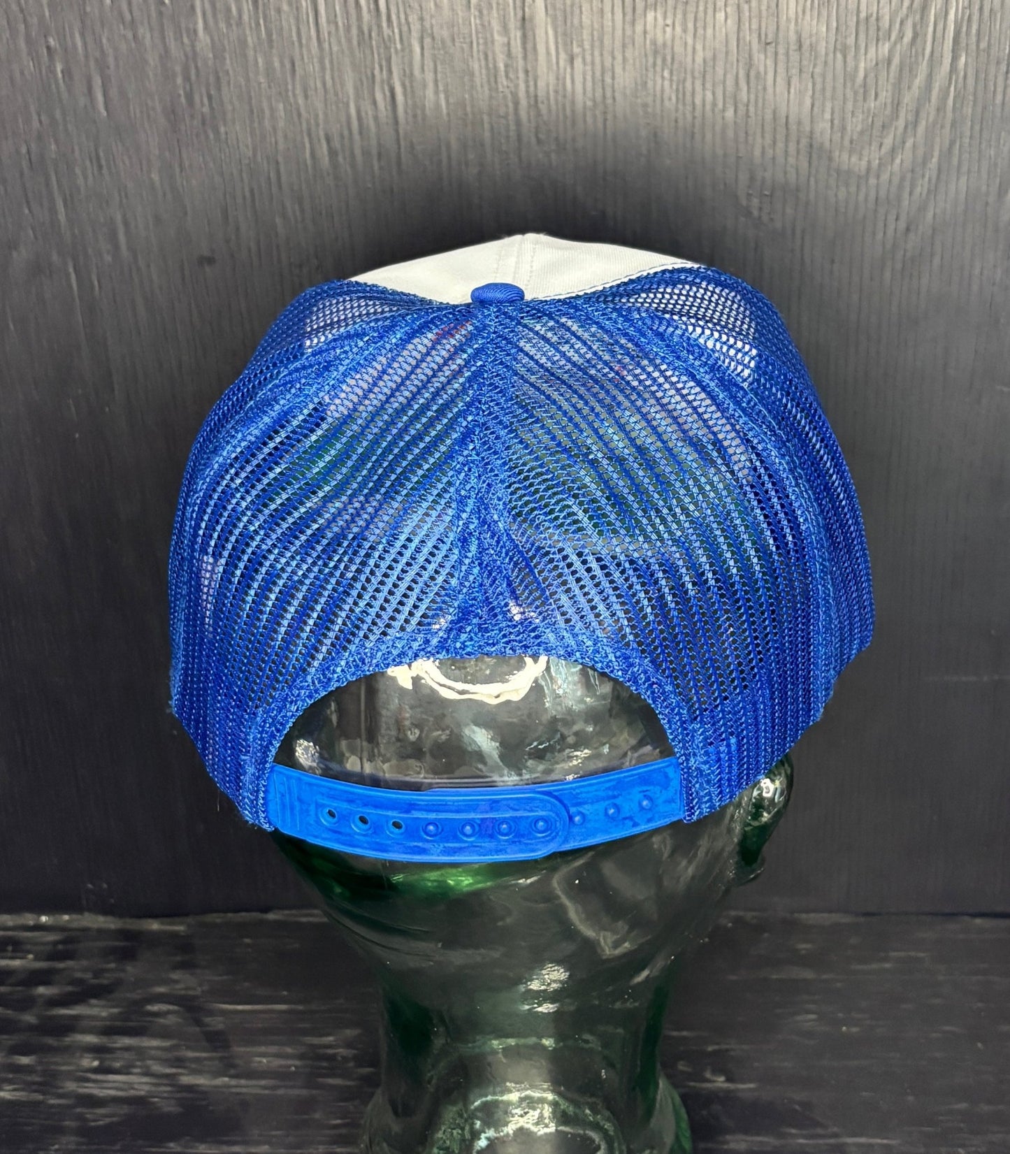 Blue mesh cap on a mannequin head against a dark background