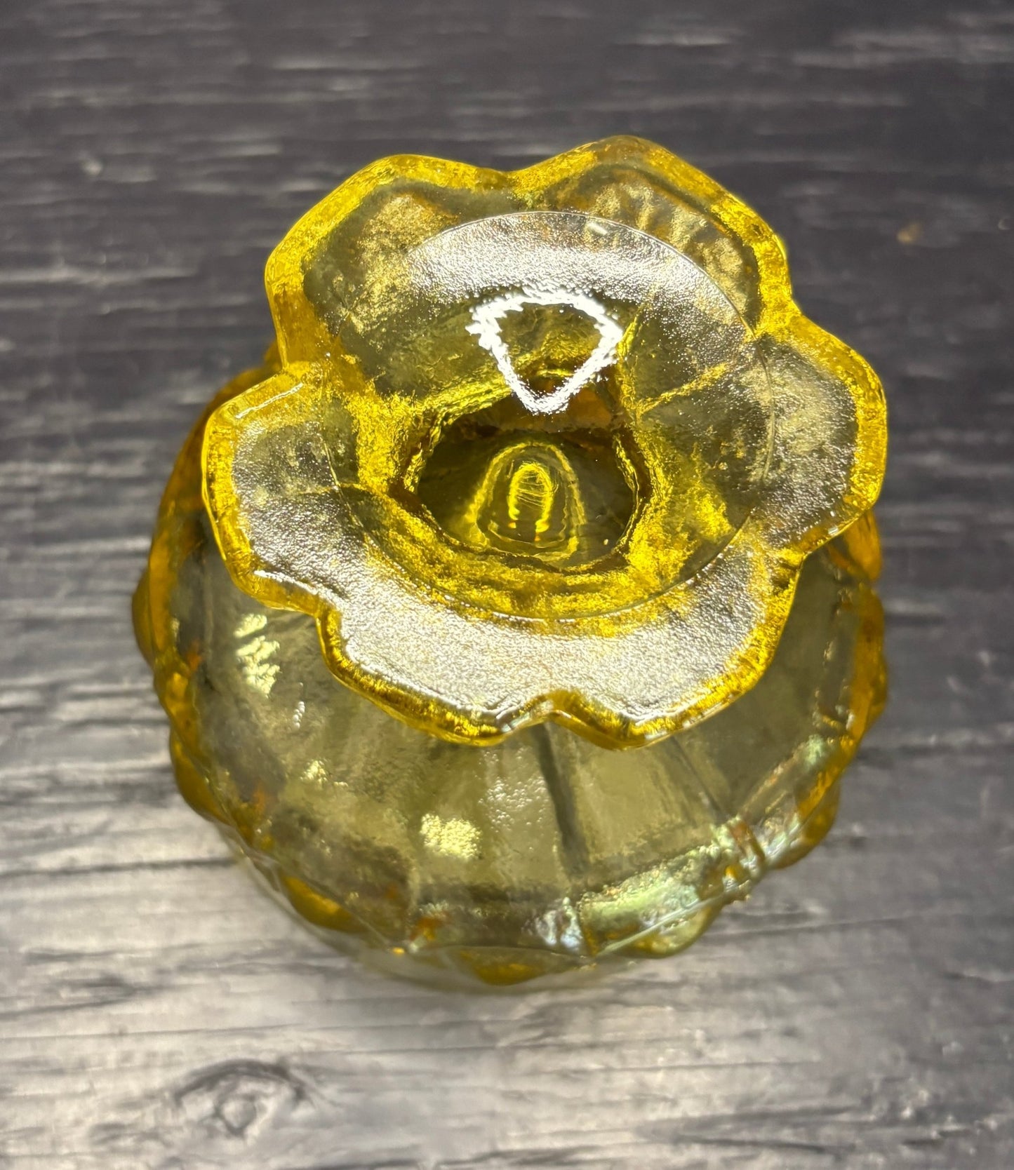 Gold-colored rose shaped bowl on a dark wooden surface