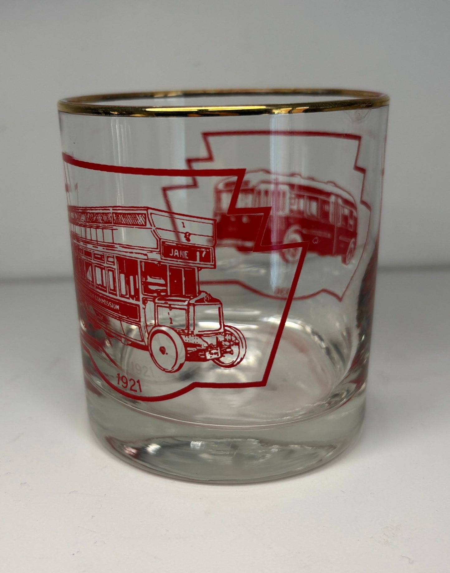 Clear glass with red graphics of a bus and buildings on a white background