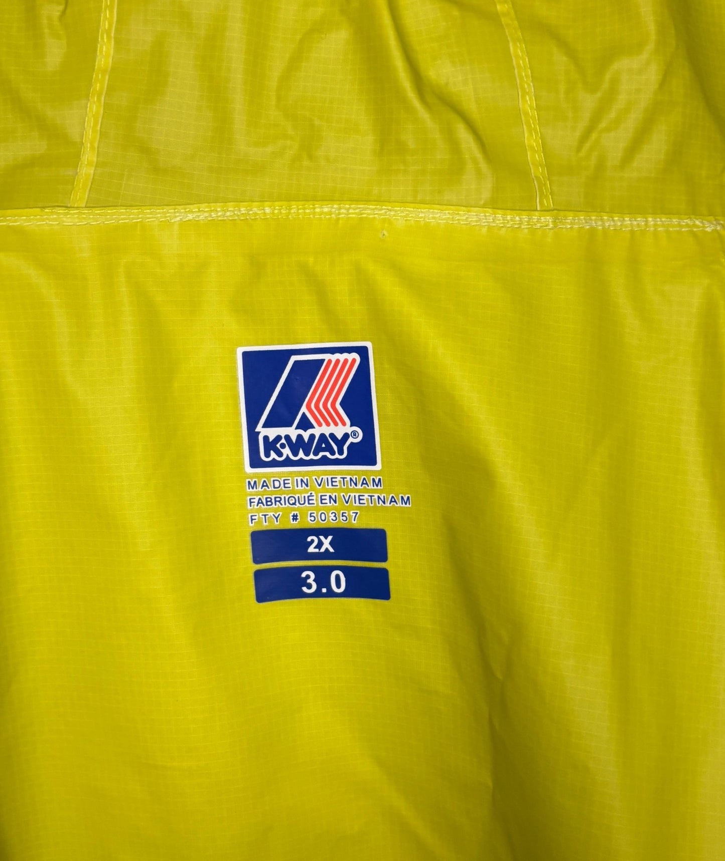 Close-up of a K-Way label on a yellow jacket