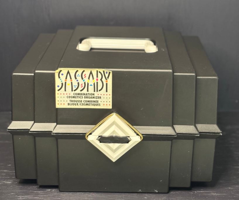 Green cosmetic organizer with a gold label on a dark background
