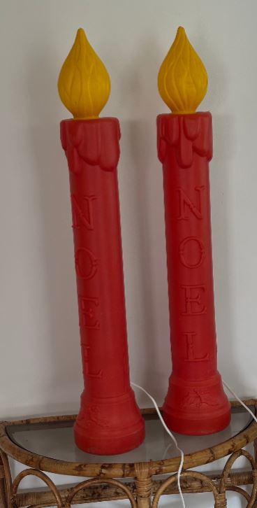 Two red candles with yellow tips on a white background