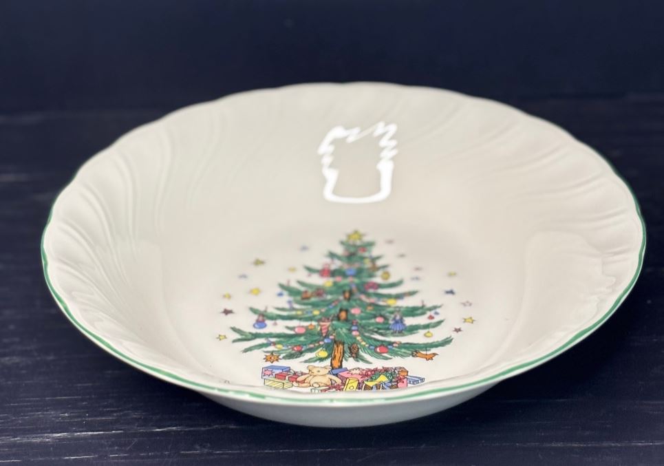 Decorative ceramic bowl with a Christmas tree design on a dark background