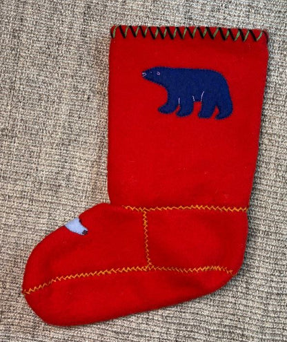 Red stocking with blue bear design on a textured surface