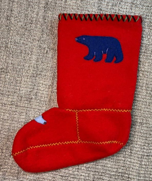 Red stocking with blue bear design on a textured surface