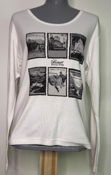 White long-sleeve shirt with black graphic designs on a mannequin against a light background