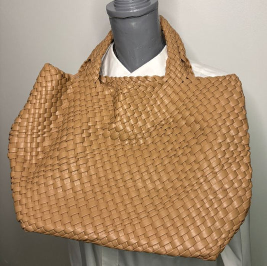 Woven brown handbag on a mannequin against a neutral background