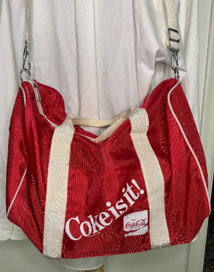 Red handbag with 'Coke is it!' text on a white background