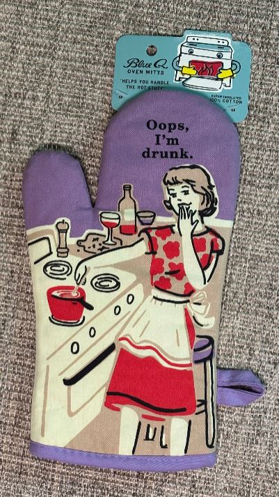 Oven mitt with humorous design of a woman saying 'Oops, I'm drunk' on a gray background