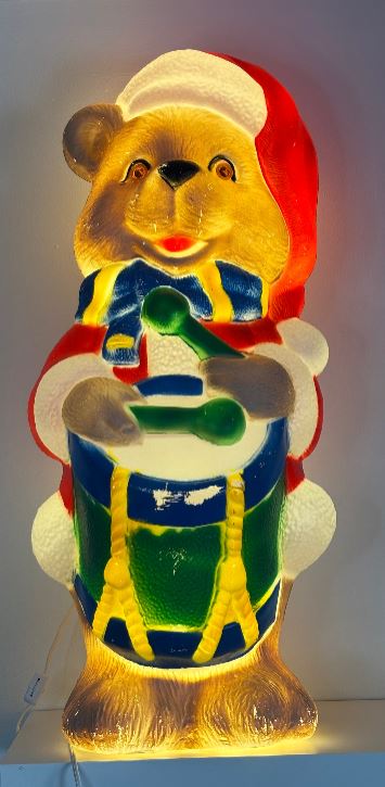 Colorful bear figurine with drum and Santa hat on a white background