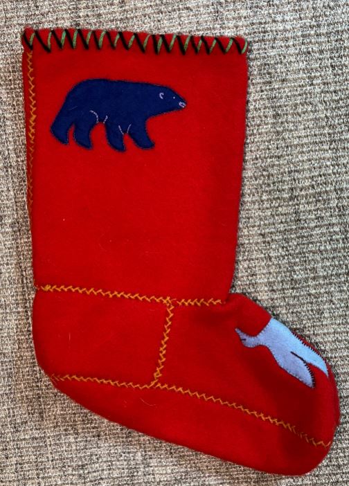 Red Christmas stocking with blue bear design on a textured surface