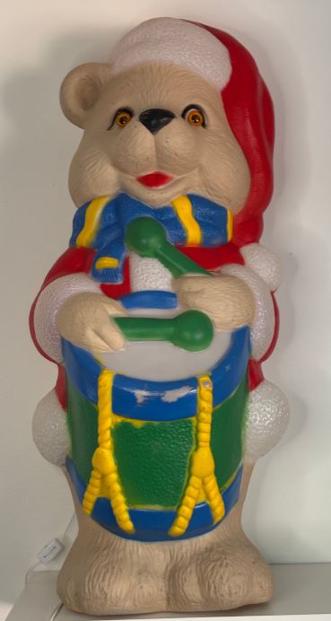 Colorful bear figurine playing a drum on a white background
