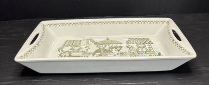 Rectangular white tray with decorative green pattern on a dark surface