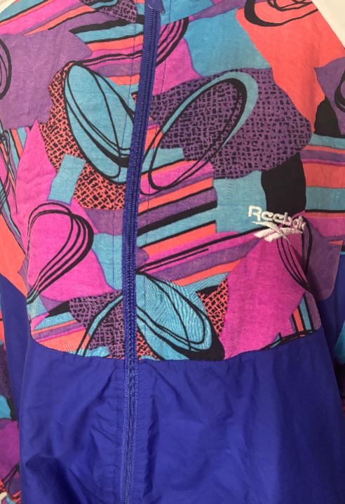 Colorful jacket with abstract patterns and a brand logo on a multicolored background