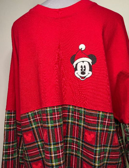 Red sweater with a cartoon character design on a plain background