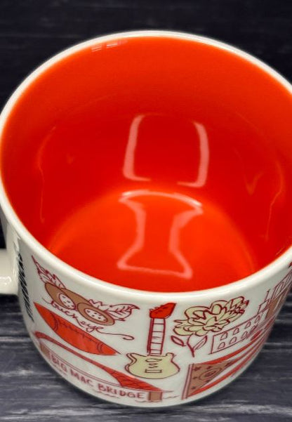 Red mug with white interior and decorative patterns on a dark surface