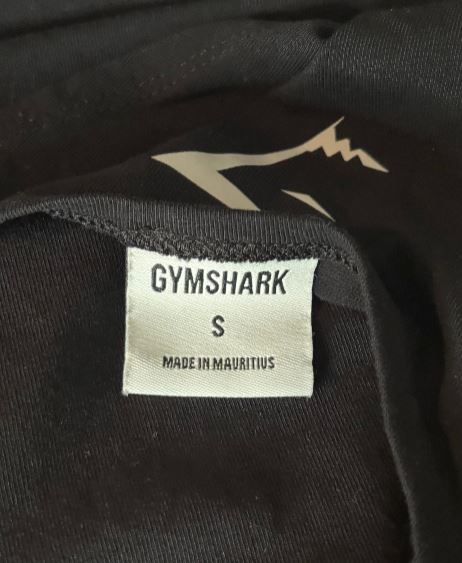 Gymshark label on a black garment with a logo.