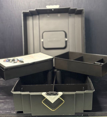 Open black jewelry box with compartments on a dark background