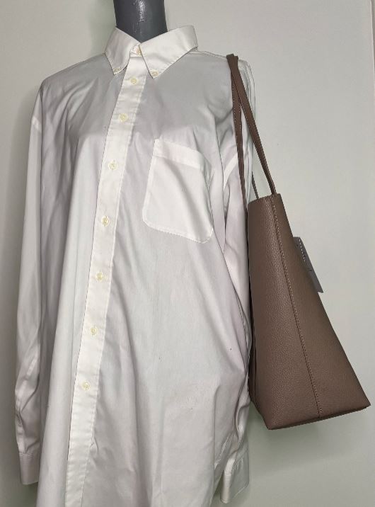 White shirt with a brown bag on a mannequin against a white background