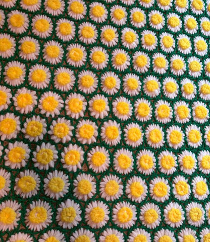Pattern of small yellow and white flowers on a green background