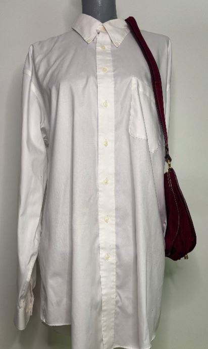 White shirt on a mannequin with a red bag over its shoulder against a white background