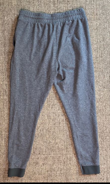 Gray sweatpants on a textured beige surface