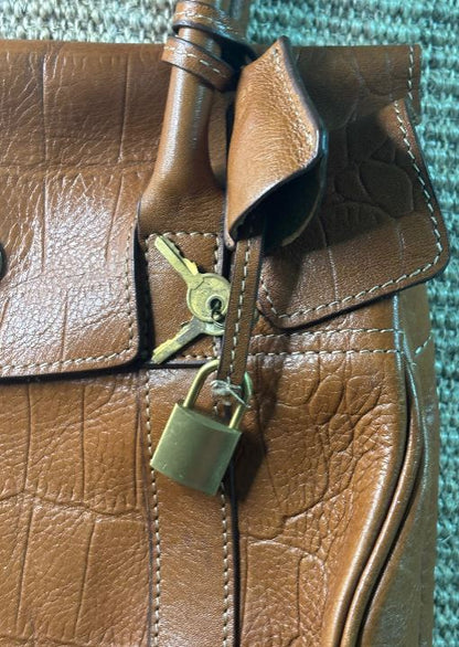 Brown leather bag with a gold padlock and keys attached