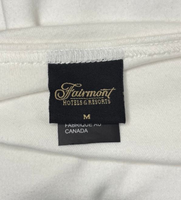 Close-up of a Fairmont Hotels & Resorts label on white fabric.