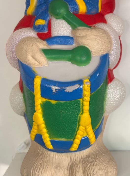 Colorful toy figure with a drum and drumsticks on a white background
