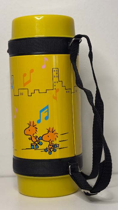 Yellow thermos with black strap featuring cartoon characters and musical notes on a white background
