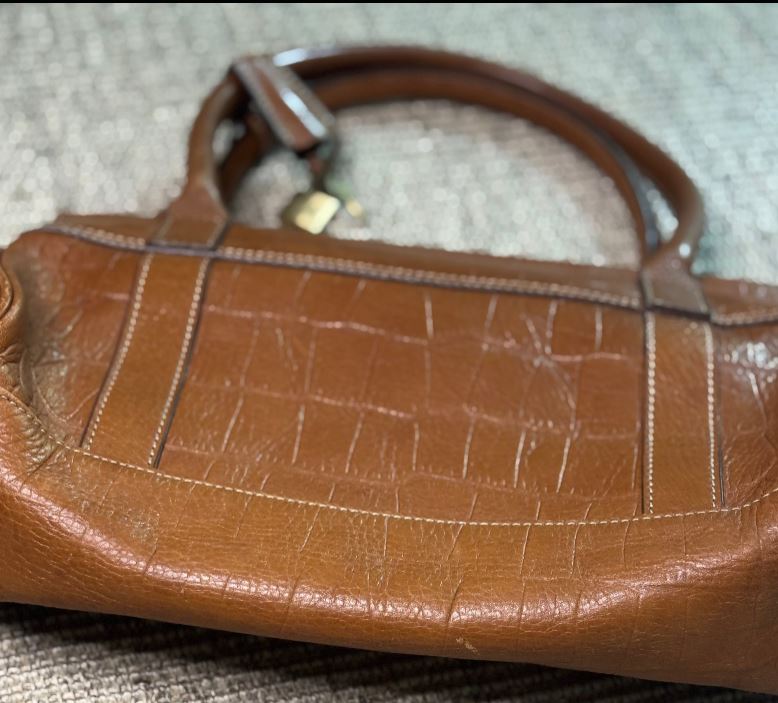 Brown leather handbag on a textured surface