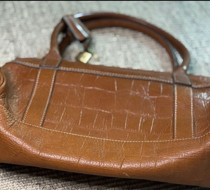 Brown leather handbag on a textured surface