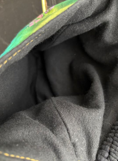 Close-up of dark fabric with a small patch of colorful embroidery.