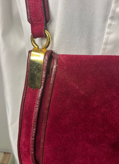 Close-up of a red handbag with a gold clasp on a white background