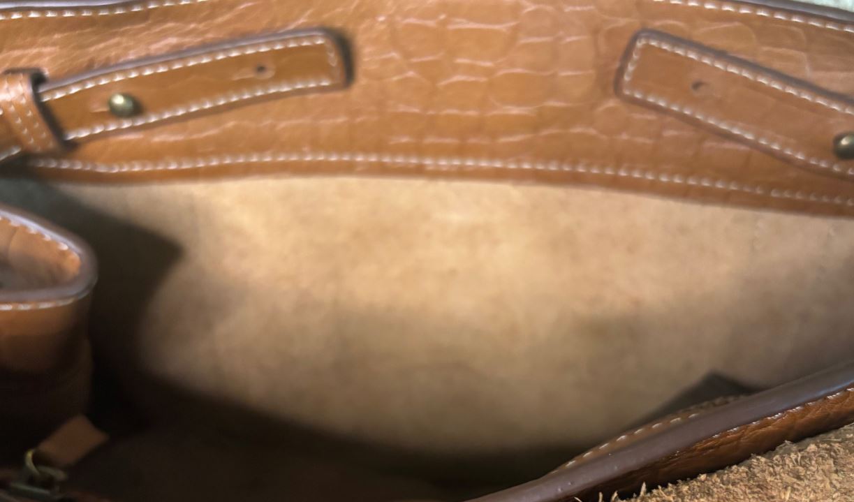 Close-up of a brown leather handbag with visible stitching