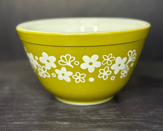Green bowl with white floral pattern on a dark surface
