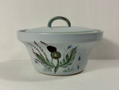 Ceramic pot with lid and floral design on a white background