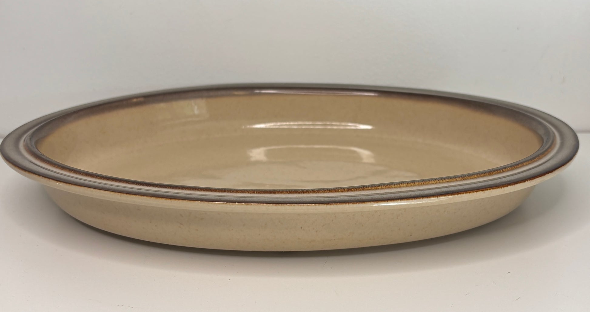 Ceramic plate with a brown rim on a white background